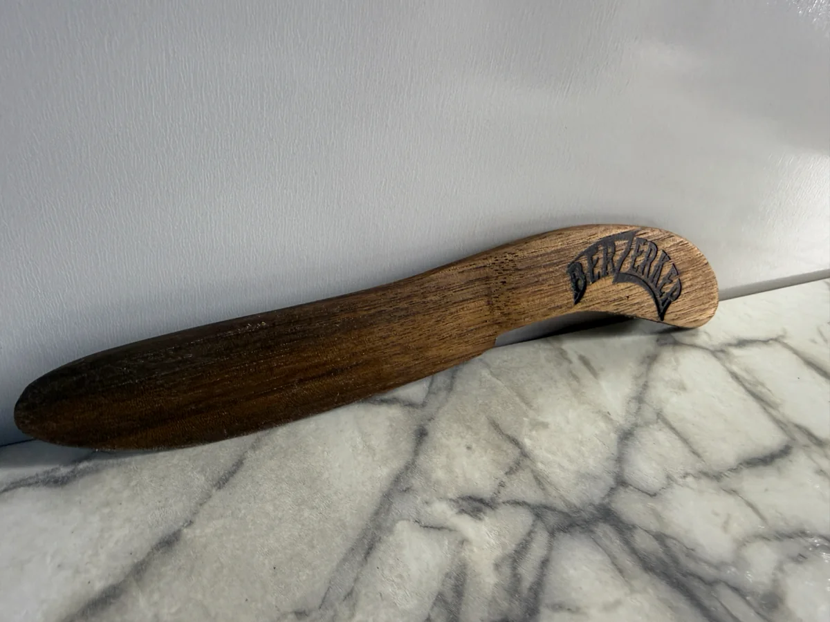 Close view of the curved wood sheath for Knife No. 1 with the dark maker's mark near the end.